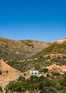 Girit 'in dağlık arazisi, dik yamaçlarda tek bir bina var.