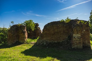 Bitkilerle kaplı terk edilmiş eski bir tuğla şatonun kalıntıları.