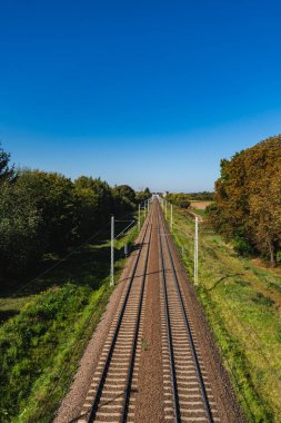 Ufukta uzanan boş demiryolu rayları olan bir manzara.