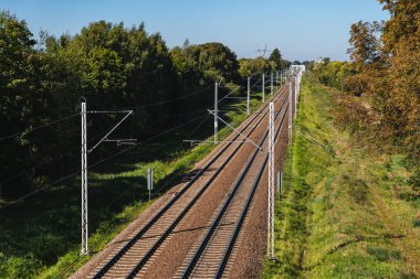 Ufukta uzanan boş demiryolu rayları olan bir manzara.