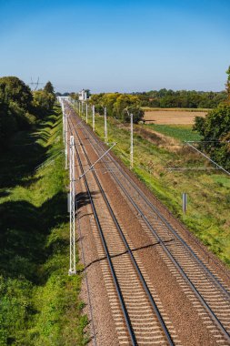 Ufukta uzanan boş demiryolu rayları olan bir manzara.