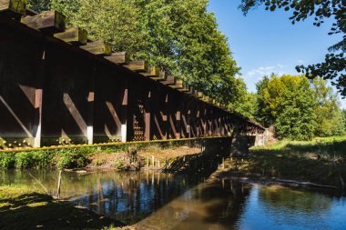 Nehirden geçen eski çelik demiryolu köprüsü olan bir manzara.