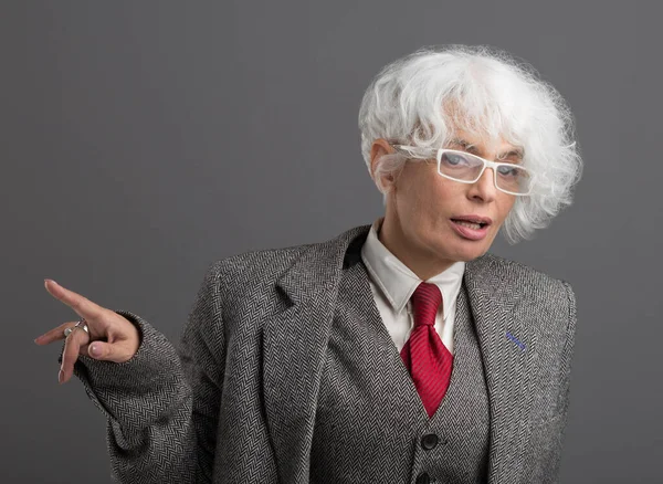 Zaostřená Bělovlasá Starší Žena Brýlích Pánském Obleku Kravatou Stojící Šedém — Stock fotografie