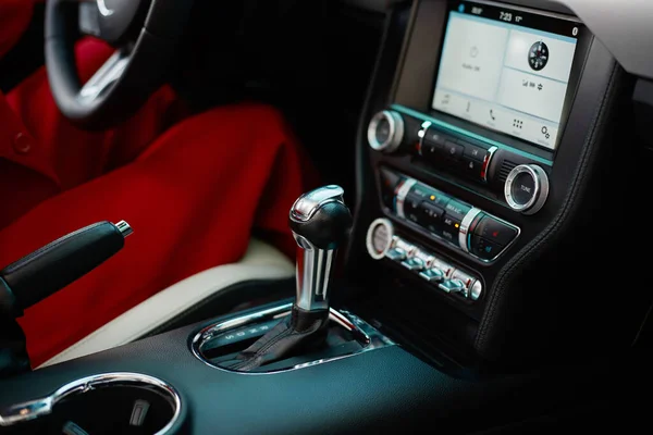 Sleek automatic transmission lever, handbrake, and multimedia panel of modern car trimmed with black leather. Harmonious blend of functionality and aesthetics in contemporary automotive interior