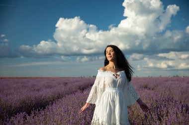 Lavanta tarlasında beyaz bir elbise giymiş genç bir kadın..
