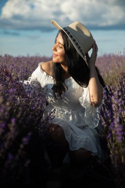 Gün batımında lavanta çiçeklerine hayran olan güzel genç bir kadın..