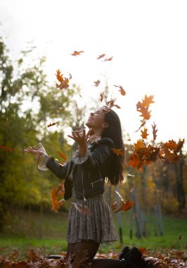 Kameranın önünde yaprak tutan güzel, gülümseyen kadın portresi..