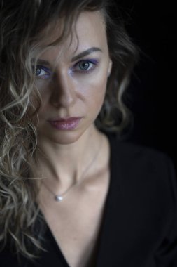 Hassas sarışın kadın, büyük mavi gözlü, doğrudan kameraya bakıyor..