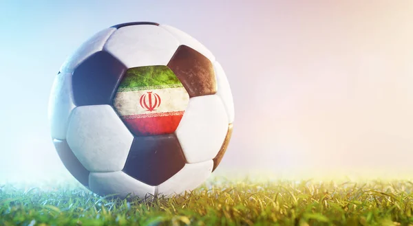 Football soccer ball with flag of Iran on grass. Iranian national team