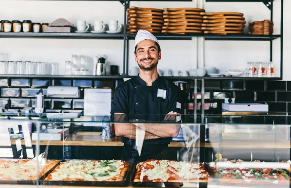 Italian chef or pizzaiolo with sicilian pizza in restaurant smiling portrait