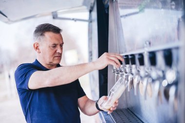 Man tasting craft beer from brewery. Middle-aged business owner, expert. clipart