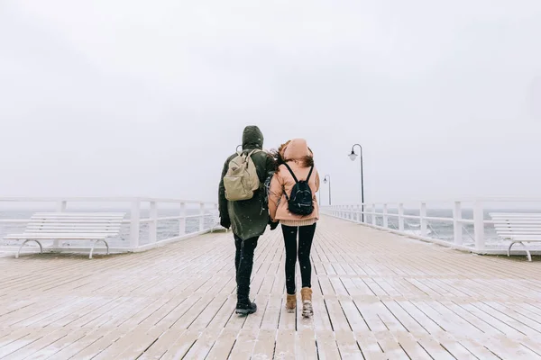 夫婦は海のそばの桟橋で冬に歩く 風と嵐の冒険 — ストック写真