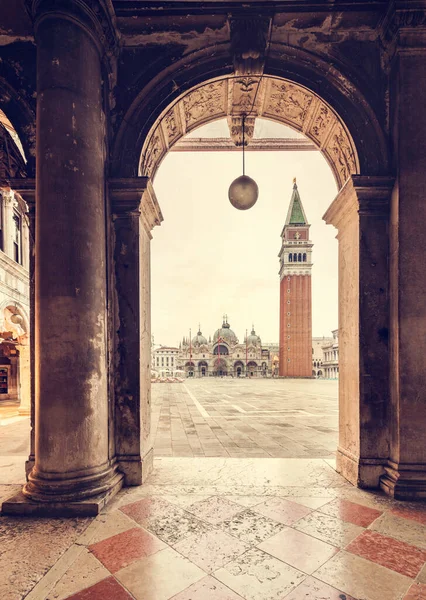 日出时意大利威尼斯圣马克广场上的拱形柱子 塔上有大教堂和坎帕尼尔斯塔 — 图库照片