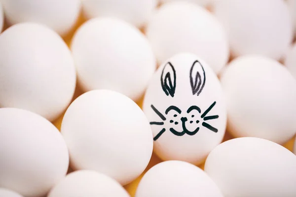 笑顔のウサギの顔と耳を描いたイースターエッグ 白い卵 — ストック写真