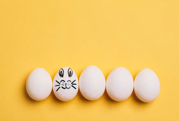 Gülümseyen Tavşan Yüzlü Kulaklı Bir Paskalya Yumurtası Beyaz Yumurtalar — Stok fotoğraf