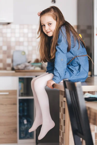 Szczęśliwa Dziewczynka Siedząca Kuchennym Stole Domu Dzieciństwo — Zdjęcie stockowe