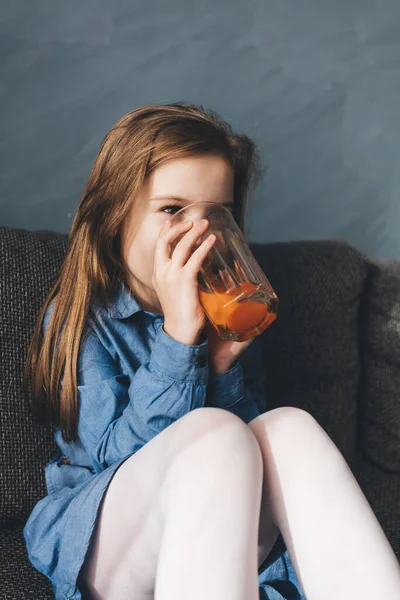 Niña Bebiendo Jugo Sofá Casa Infancia —  Fotos de Stock