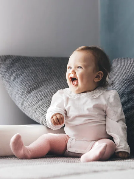幸せな幼児の赤ちゃんの女の子は自宅でソファで笑っています 幼少期 — ストック写真