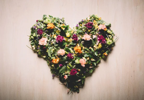 Vahşi Bahar Çiçeklerinden Yapılmış Kalp Şekli Tahta Arka Planda Yapraklar — Stok fotoğraf