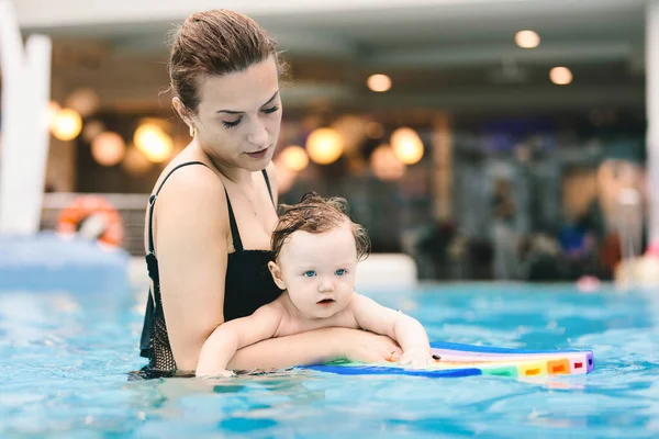 母と彼女の赤ちゃんの娘はウォーターパークのプールで泳ぐ 最初の水泳 — ストック写真