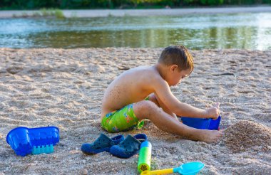 little boy on the beach playing in the sand