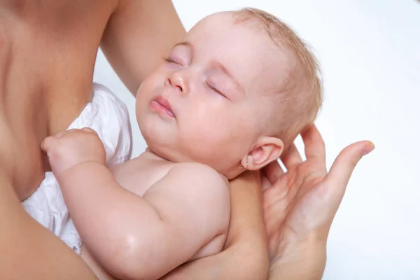 赤ん坊は母の手の上で軽い背景で眠り — ストック写真