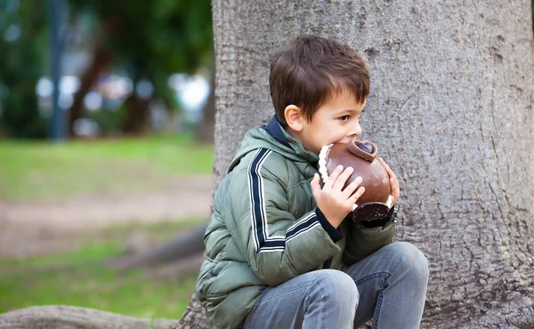 公園でイースターチョコレートの卵を持つ幸せな男の子 — ストック写真