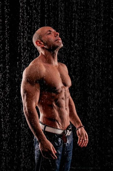Αθλητής Bodybuilder Κάτω Από Πίδακες Βροχής Μαύρο Φόντο — Φωτογραφία Αρχείου