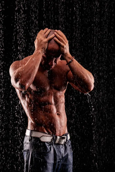Atleet Bodybuilder Onder Jets Van Regen Een Zwarte Achtergrond — Stockfoto