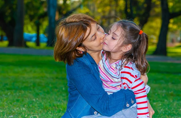公園の芝生の上で娘と幸せな母親 — ストック写真