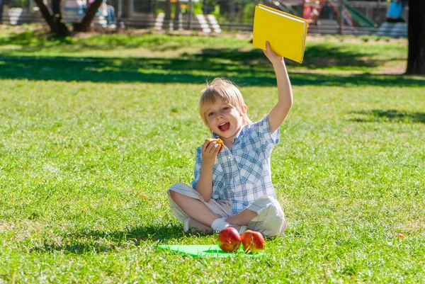 Petit Garçon Avec Une Pomme Livre Dans Parc — Photo