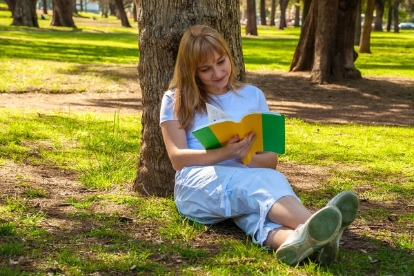 Flicka Med Bok Sitter Nära Ett Träd Parken — Stockfoto