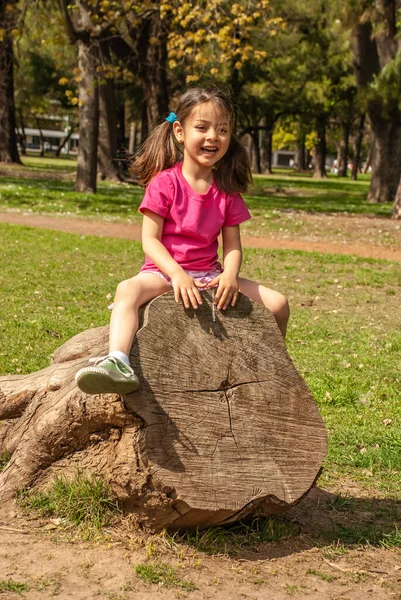 Parktaki Ağaçta Oturan Neşeli Küçük Kız — Stok fotoğraf