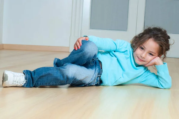 stock image little girl lying on the floor in the room