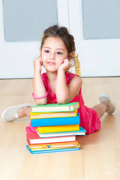 在幼儿园的地板上坐着一本书的女孩 — 图库照片
