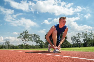 Stadyumda koşu bandında genç bir sporcu