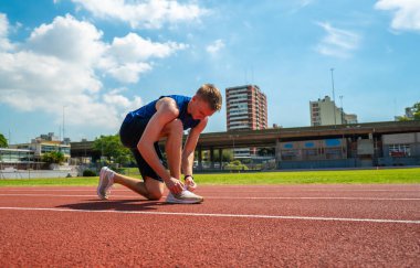Stadyumda koşu bandında genç bir sporcu