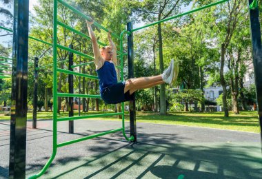 Parkta spor malzemeleriyle egzersiz yapan genç bir sporcu.