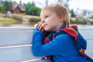 Bankta mutlu küçük bir çocuğun portresi