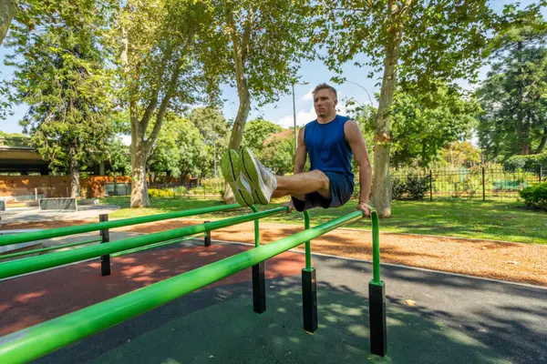 公園のスポーツ用具で運動する若い男選手 ロイヤリティフリーのストック写真