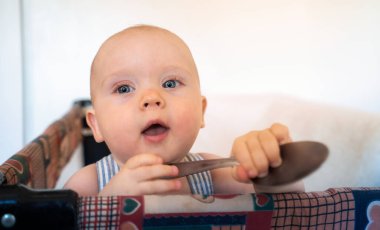 Kareli gömlekli küçük bir çocuk ve beşiğinde bir fiyonk..