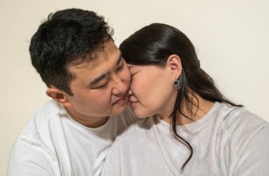 Bir erkek ve bir kadın birbirlerine sarılıyorlar. Adam beyaz bir gömlek giyiyor ve kadın beyaz bir gömlek giyiyor.