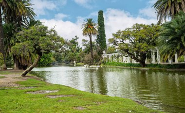 Göletli ve ağaçlı bir park. Ağaçlar çıplak ve gölet sakin. Parkta hiç insan yok.