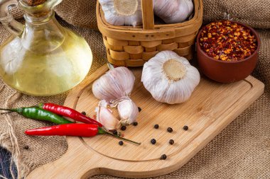 Kesme tahtasındaki sarımsak soğanları, sebze yağı ve biber kabukları kapanıyor..