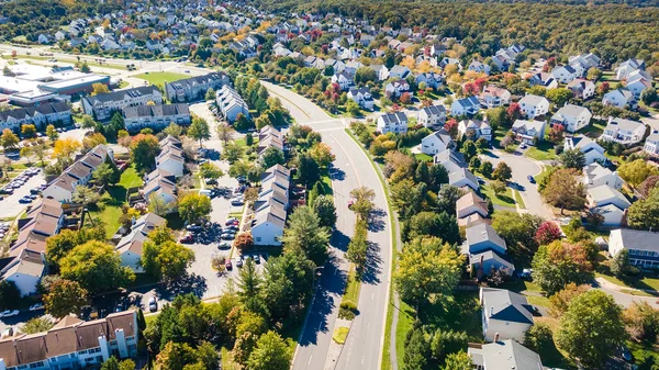 Aerial view of upscale residential area, gated community street real estate with single family homes. Autumn sunny day.