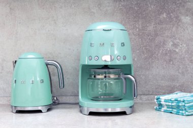 Mutfak tezgahının üstünde sıra sıra SMEG brank mutfak gereçleri, kahve makinesi elektrikli çaydanlık, popüler İtalyan imalatçı