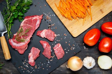 Dilimlenmiş çiğ et ve pişirmek için hazırlanmış sebzeler. Yukarıdan görüntüle.