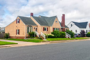 Yolun kenarındaki güzel bekar aile evi. Çalılar, çiçekler ve çimenler evin dışını süslüyor..