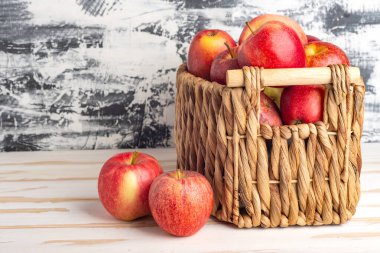 Hasat edilmiş taze elma hasat sepetinde beyaz masada. Metin için boşluk.