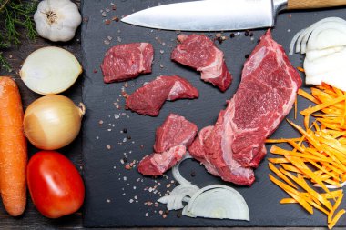 Dilimlenmiş çiğ et ve pişirmek için hazırlanmış sebzeler. Yukarıdan görüntüle.